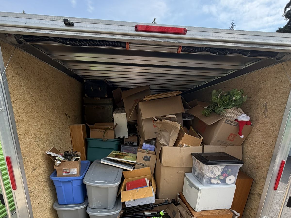 Enclosed trailer loaded with moving boxes, storage totes, and household goods during a Portland estate cleanout